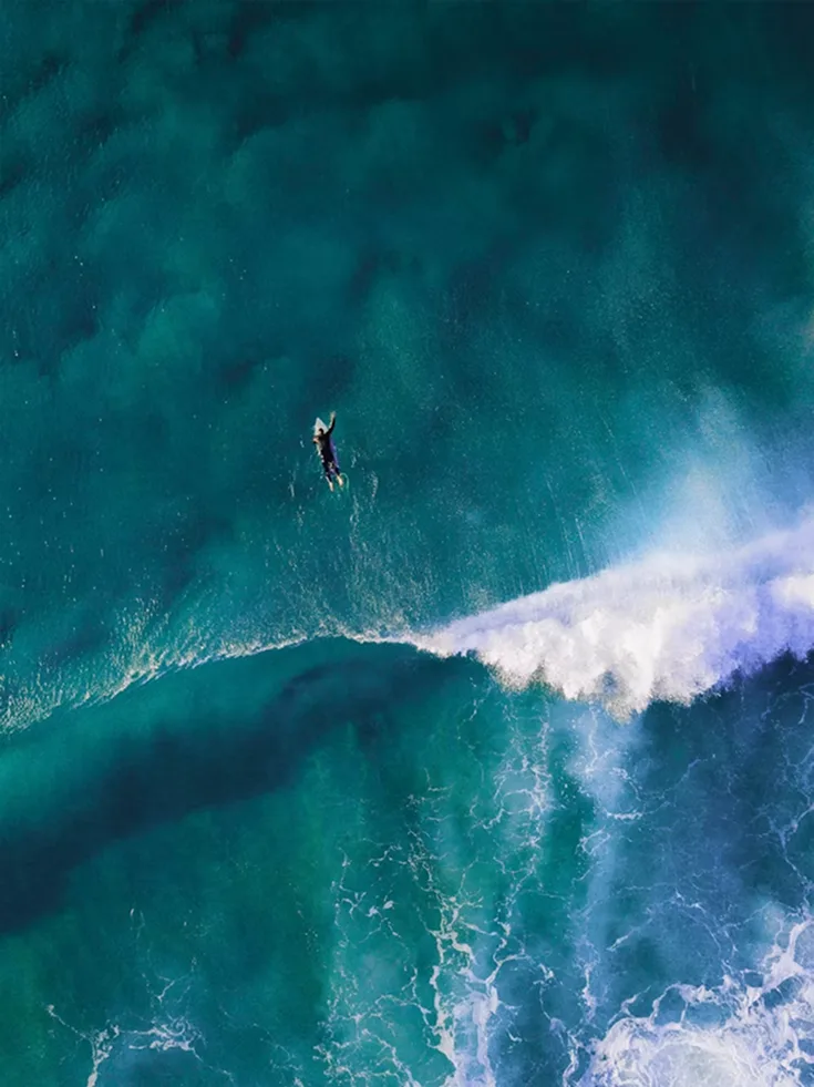 Aerial surfer in blue water