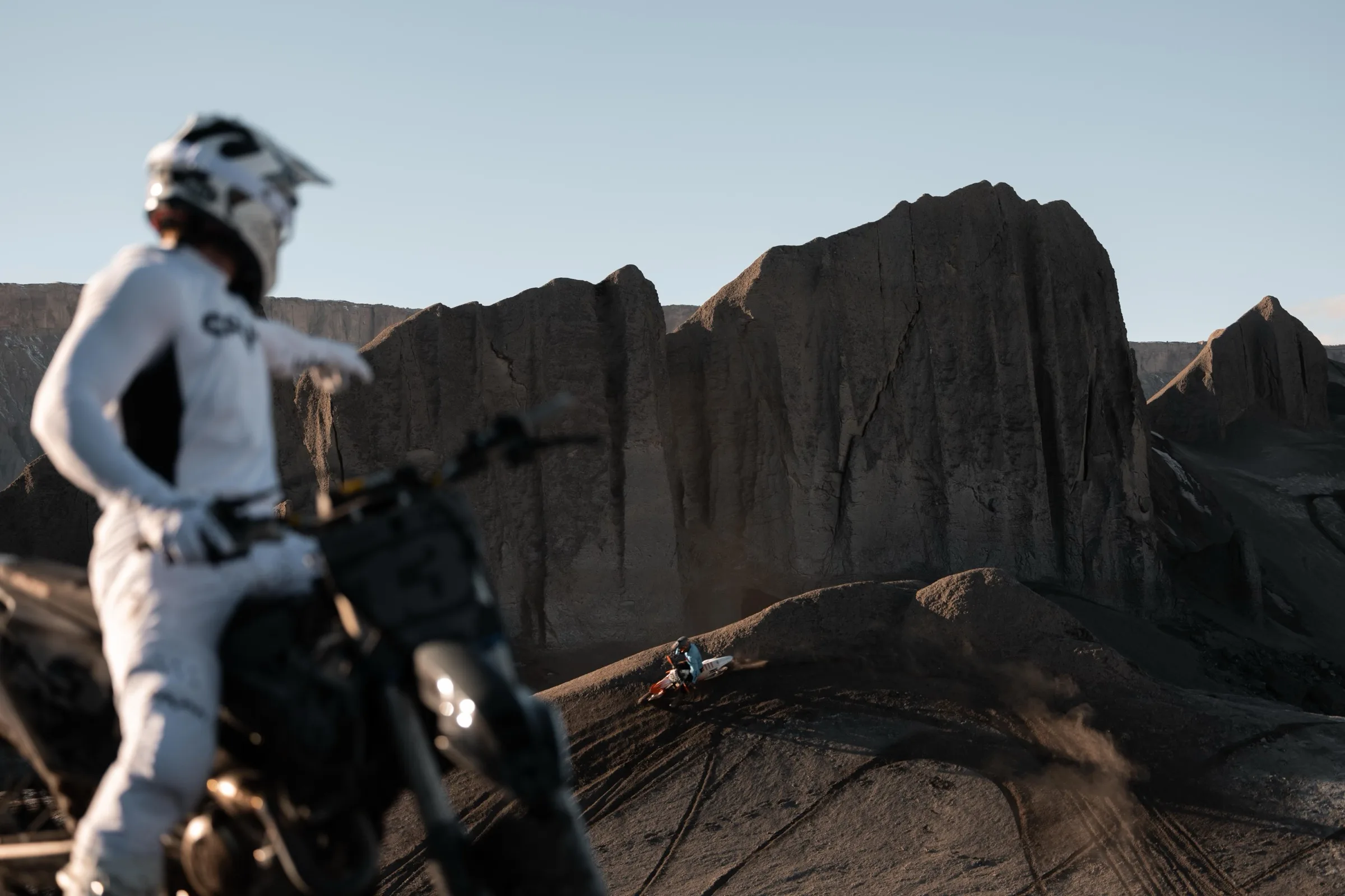 Rider watching a teammate ride the desert ridge