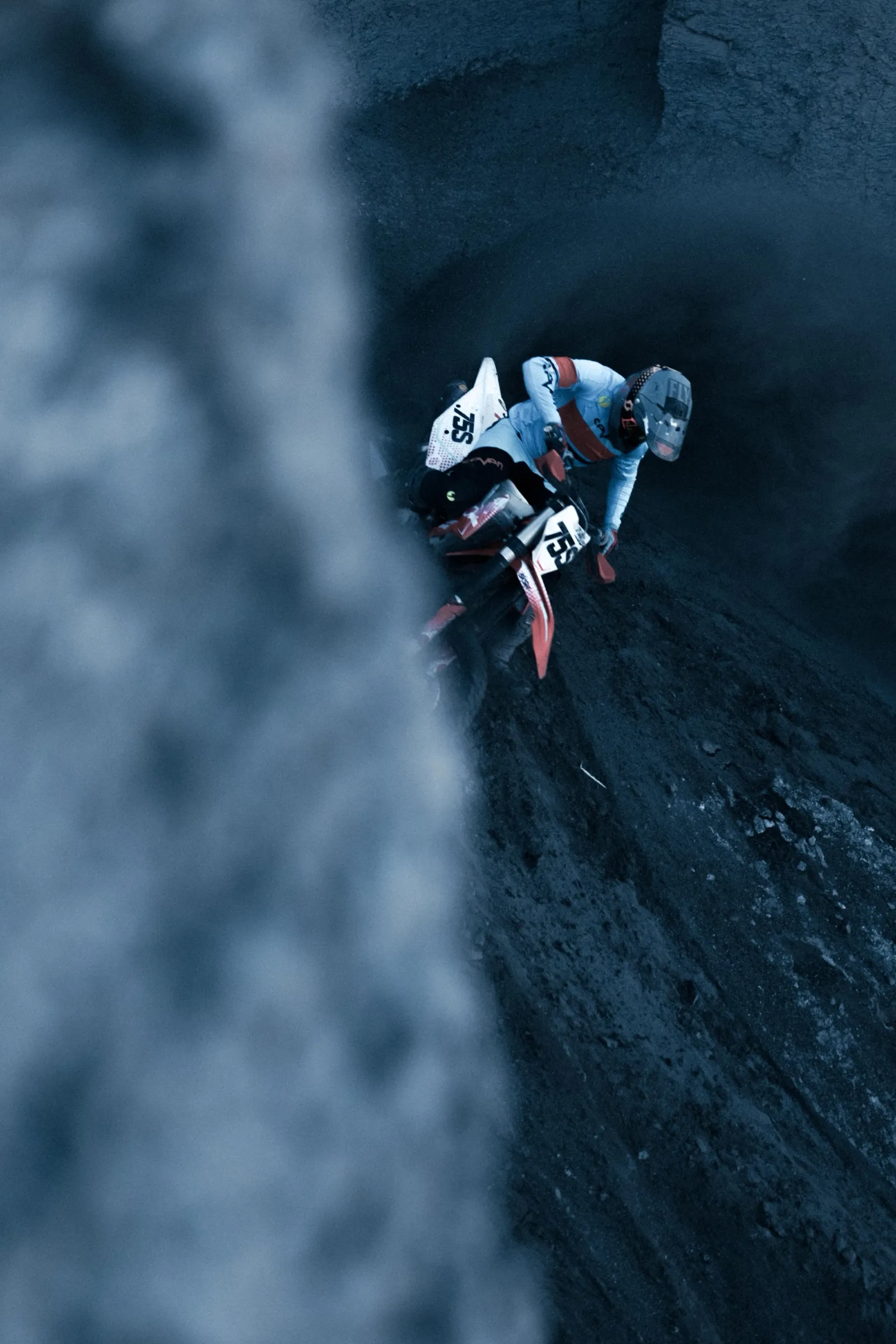 Motorcycle rider leaning into a steep dark climb