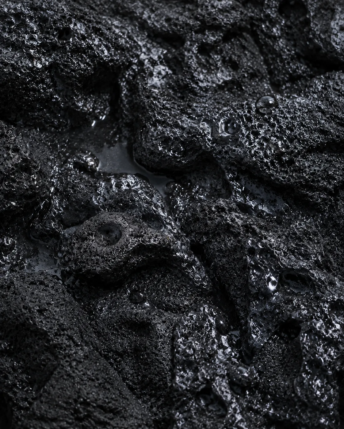 Wet black volcanic stone texture